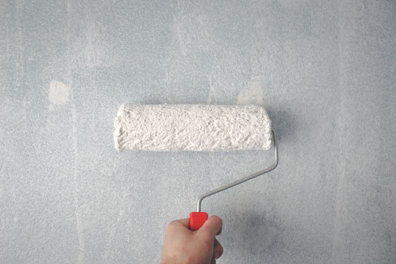 Person Holding Paint Roller On Wall staging a house for sale by realtor san francisco